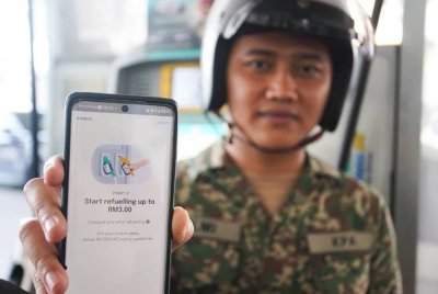 Anggota Tentera, Koperal Hilmi Azlan,29, menunjukkan aplikasi Setel pada pelaksanaan BUDI MADANI RON95 (BUDI95) di Stesen Minyak Petronas, Setiawangsa, Sabtu lalu.