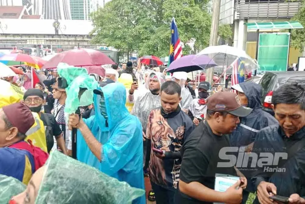 Para peserta tidak berganjak walaupun cuaca hujan ketika menyertai protes terhadap sekatan misi Global Sumud Flotilla (GSF) berdekatan Kedutaan Amerika Syarikat, Jalan Tun Razak di sini, pada Jumaat.