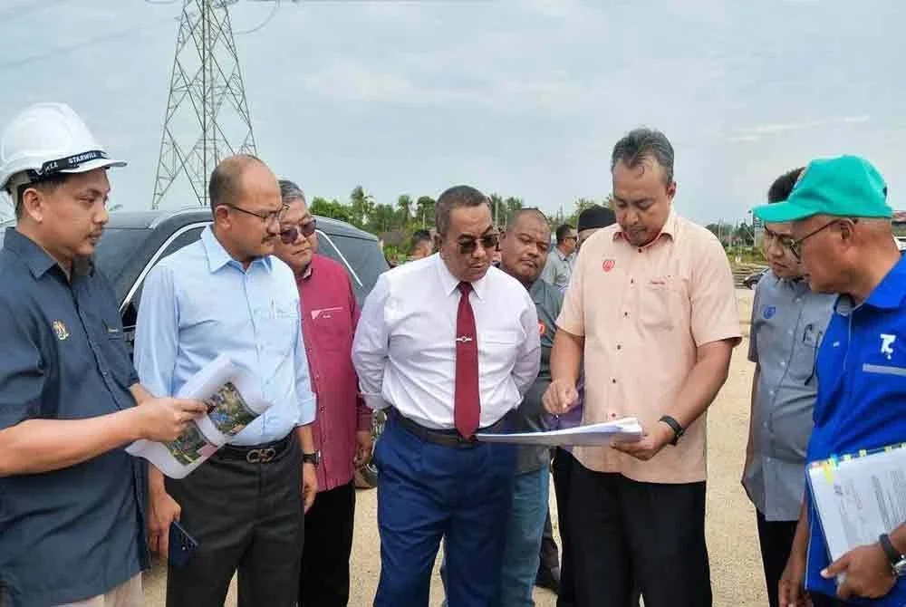 Muhammad Sanusi (tengah) diberikan taklimat perkembangan projek pembinaan jambatan baharu ketika mengadakan lawatan kerja ke tapak projek RTB Sungai Kedah/Anak Bukit di Titi Kuala Sungai, pada Selasa.