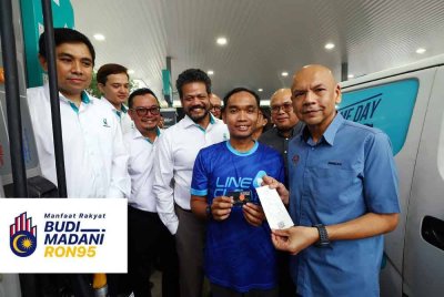 Armizan (kanan) bersama kakitangan Line Clear Express Sdn Bhd Muhammad Azim Asyraf Nasaruddin (dua kanan) menunjukkan resit pembelian minyak petrol dengan menggunakan kad fleet pada Majlis Penyerahan Kad Fleet di Stesen Minyak Petronas, Cyberjaya hari ini. - Foto: Bernama