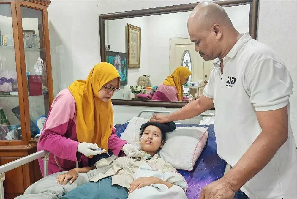 Fatimah yang terlantar sakit ditemani ibu dan bapanya di rumah mereka di Taman Semabok Jaya pada Jumaat.