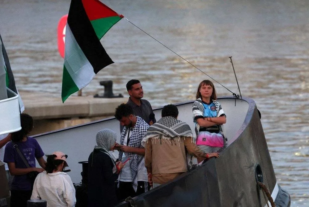 Thunberg (kanan) berada di atas kapal flotila awam membawa aktivis pro-Palestin dan bantuan kemanusiaan di Pelabuhan Barcelona. - AFP