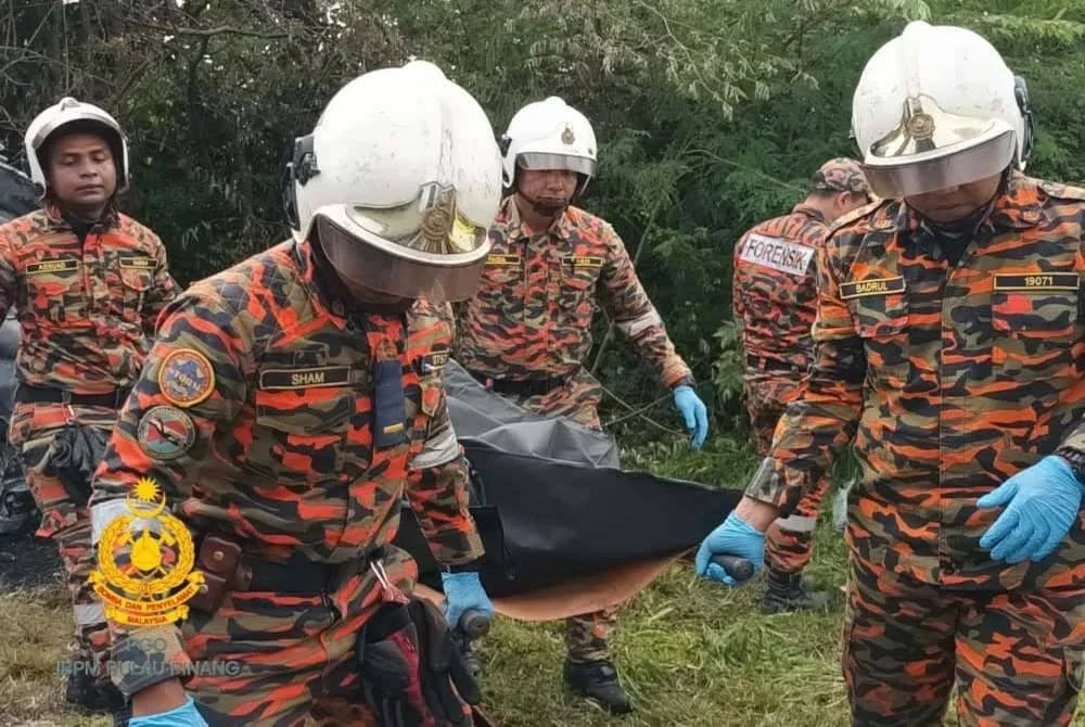 Anggota bomba mengangkat mayat mangsa kemalangan yang rentung di Jalan Permatang Baru, Sungai Lokan pada Sabtu.