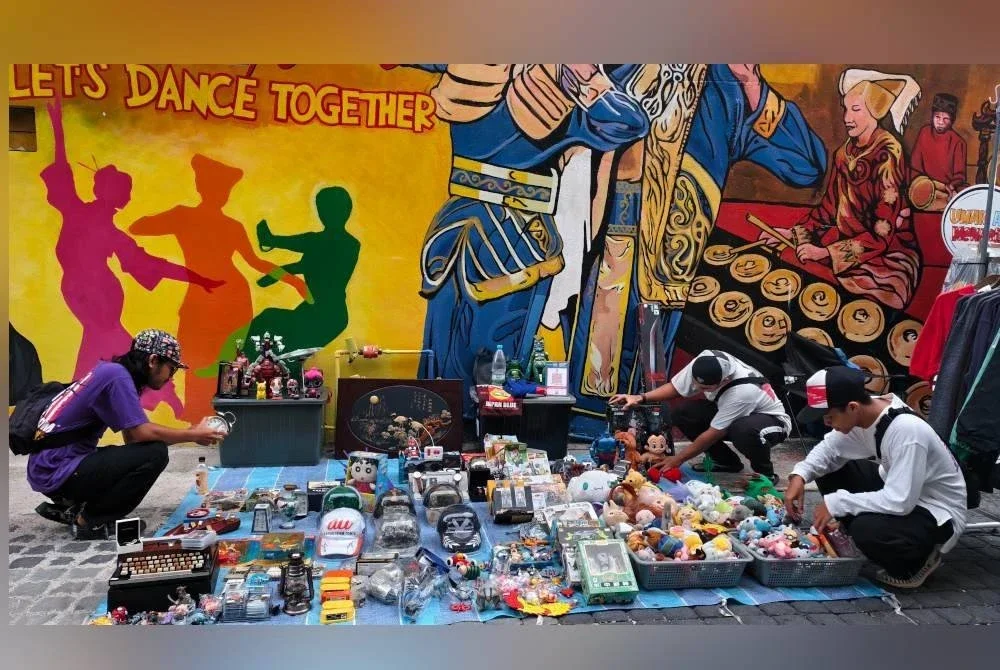 Peniaga menyusun barang perniagaan mereka di pasar karat di Lorong Seni Seremban.