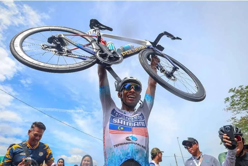 Reaksi pelumba Terengganu Cycling Team (TSG), Muhammad Nur Aiman Rosli mengangkat basikalnya selepas menamatkan saingan di tempat kedua pada perlumbaan peringkat ketujuh Le Tour de Langkawi (LTDL 2025) dari Melaka ke Medini hari ini. Foto Bernama