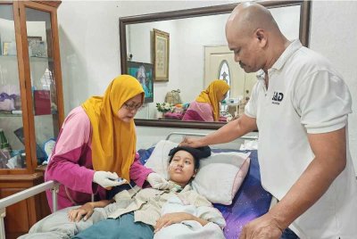 Fatimah yang terlantar sakit ditemani ibu dan bapanya di rumah mereka di Taman Semabok Jaya pada Jumaat.