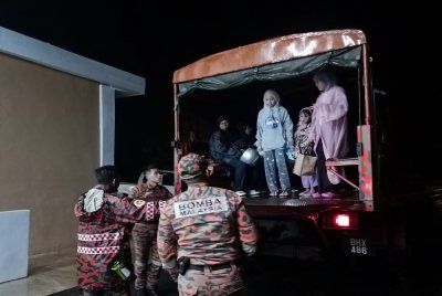 Anggota bomba membantu memindahkan mangsa banjir. Foto media sosial