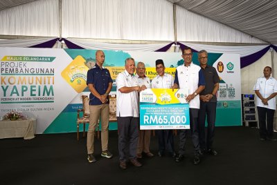 Abdul Khudus (tengah) menyaksikan penyerahan sumbangan kepada penerima sempena Majlis Projek Pembangunan Komuniti YAPEIM (PPKY) Peringkat Negeri Terengganu di Tasik Kenyir, Hulu Terengganu pada Sabtu.