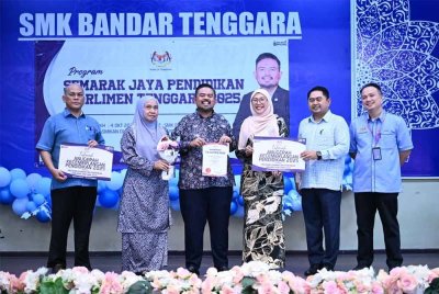 Manndzri (tiga dari kiri) menyampaikan sumbangan kepada penerima sempena program Semarak Jaya Pendidikan Parlimen Tenggara di SMK Bandar Tenggara pada Khamis.