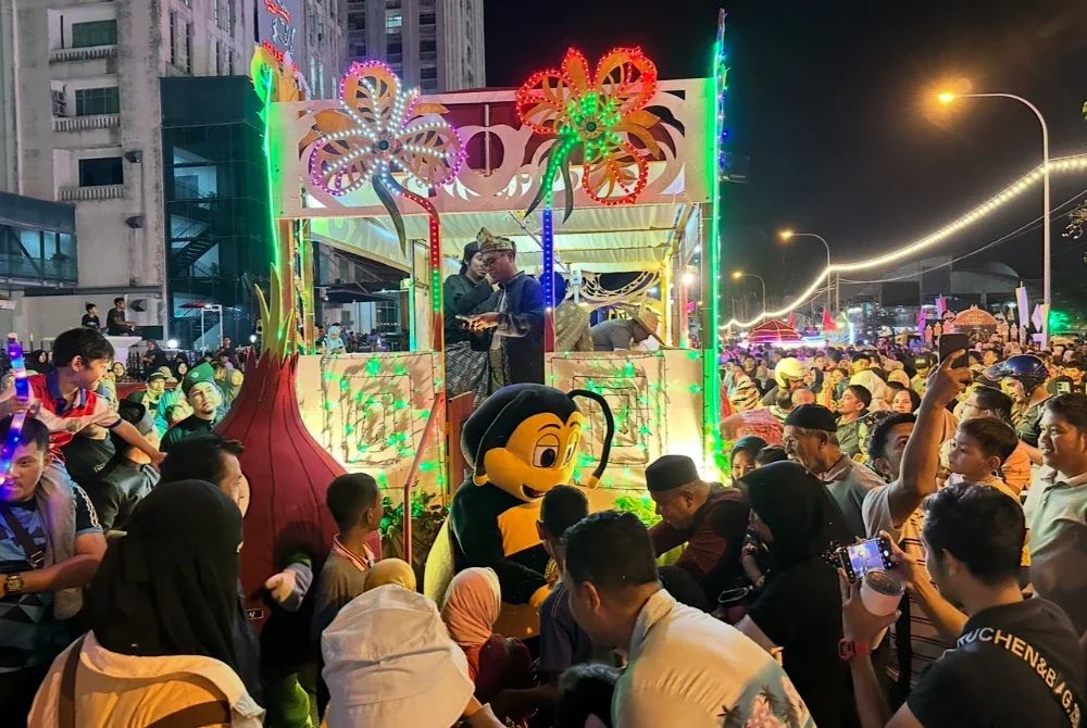 Orang ramai yang memenuhi bandar Kota Bharu bagi menyaksikan perarakan kenderaan berhias.