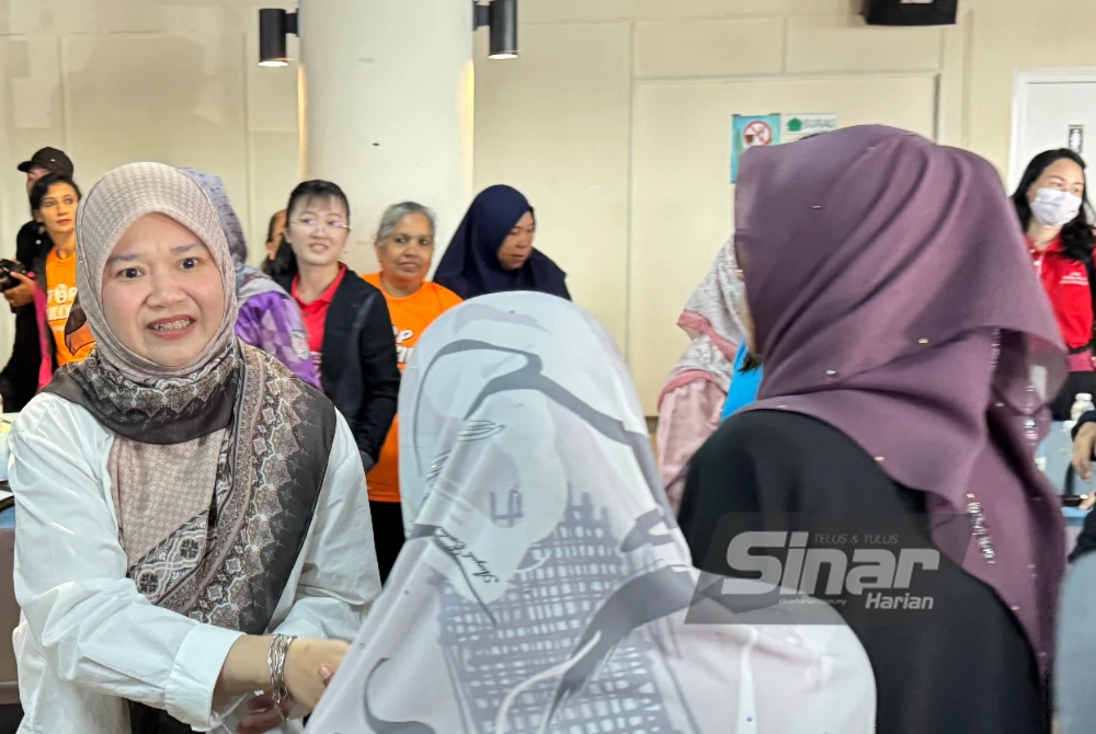 Fadhlina (kiri) bersalaman dengan peserta yang menghadiri Kempen Jelajah Anti Buli 2025 di Penanti pada Ahad.