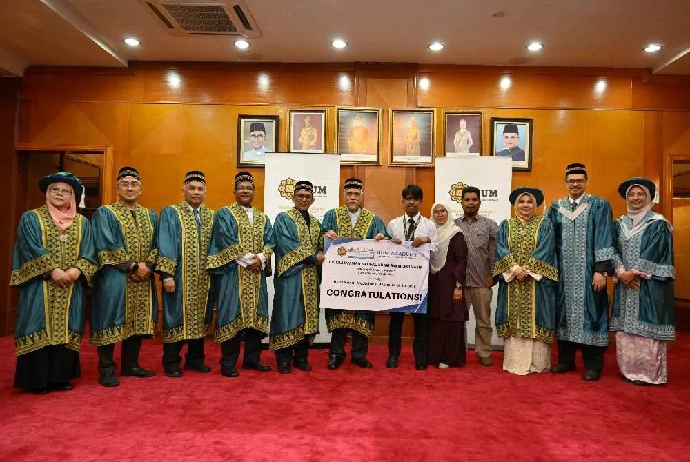 Muhammad Naufal Adam (enam dari kanan) bersama pengurusan universiti pada majlis penyerahan biasiswa di UIAM Gombak.