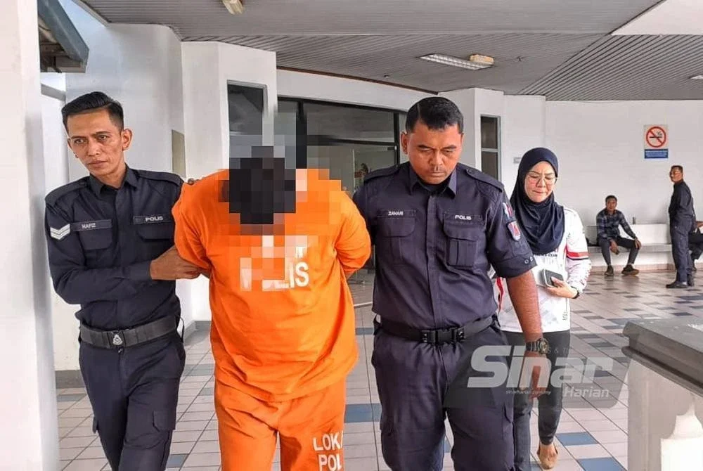 Suspek (tengah) ketika dibawa keluar dari Mahkamah Majistret di sini pada Ahad.