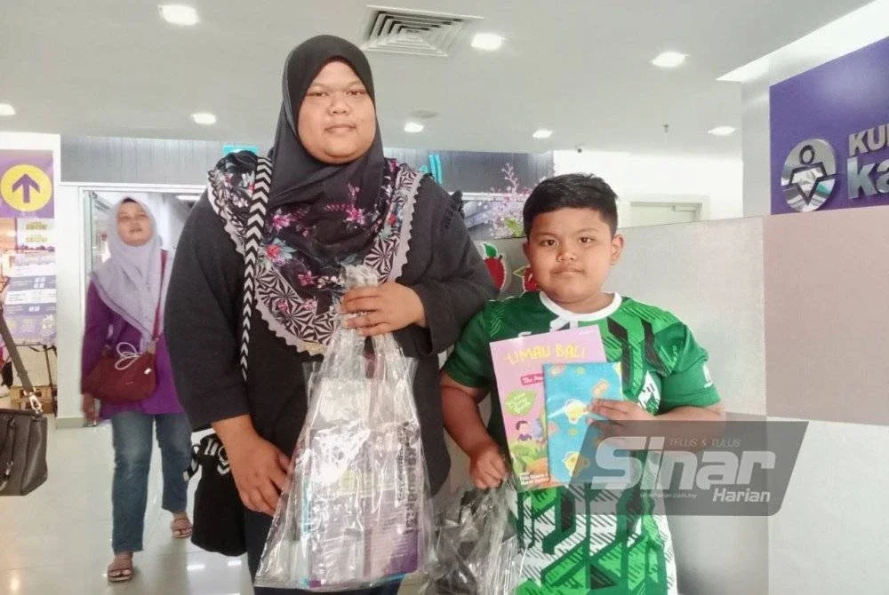 Nur Syahida bersama anaknya tidak melepaskan peluang membeli-belah di Jualan Gudang Karangkraf 2025.