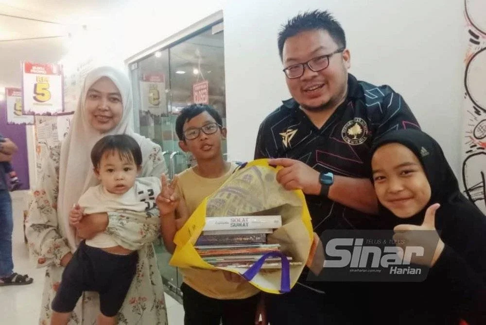 Abdul Fatah bersama keluarganya menunjukkan buku-buku yang dibelinya.