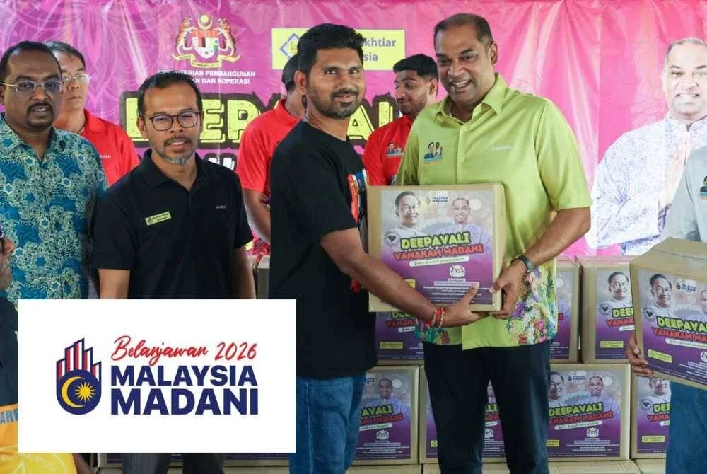 Ramanan (dua dari kanan) menyampaikan sumbangan Bakul Kasih kepada penerima pada program sumbangan Deepavali Vanakam Madani di Sungai Buloh pada Ahad.
