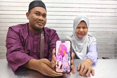 Mohd Hafizey dan Mas menunjukkan gambar perkahwinan mereka yang berlangsung pada 23 September di PERTIS, Seberang Takir, Kuala Nerus.