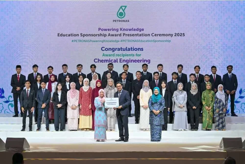 Ruslan (kanan) menyampaikan penghargaan tahniah kepada penerima Anugerah Tajaan Pendidikan Petronas 2025.