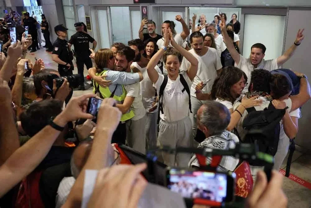 Aktivis Sepanyol (berbaju putih) bertepuk tangan ketika tiba di Lapangan Terbang Madrid-Barajas. Sepanyol memaklumkan bahawa 21 daripada 49 warganegaranya yang ditahan dalam misi flotila bantuan Gaza dijadualkan pulang dari Israel ke tanah air pada 5 Oktober. Foto AFP