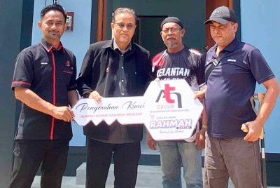 Azman (dua dari kiri) bersama Norlisan (kiri) menyerahkan replika kunci kepada penerima pada Majlis Penyerahan Kunci Rumah Ihsan Rahmah di Kampung Pantai Mek Mas di Kota Bharu pada Isnin. Foto: SINAR HARIAN/HAZELEN LIANA KAMARUDIN