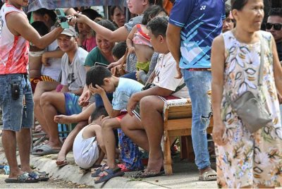 Orang ramai berkumpul di tempat perlindungan sementara di luar rumah mereka susulan Taufan Super Haiyan di Bogo City, wilayah Cebu pada 2 Oktober lalu - Foto: AFP