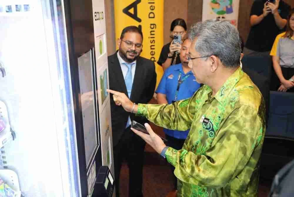 Ketua Pegawai Eksekutif SW CORP, Khalid Mohamed, mencuba mesin ECOPOD sambil diperhatikan Pengurus Pemasaran Etika Sdn Bhd,
Dr. Kalithasan Sothinathan