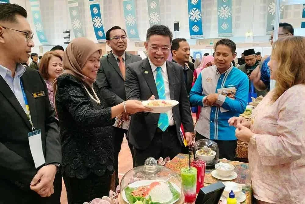 Hon Wai (depan, tiga dari kiri) mendengar penjelasan mengenai menu hidangan yang disediakan pada Persidangan Kebangsaan Warisan Kebudayaan Tidak Ketara 2025 pada Selasa.