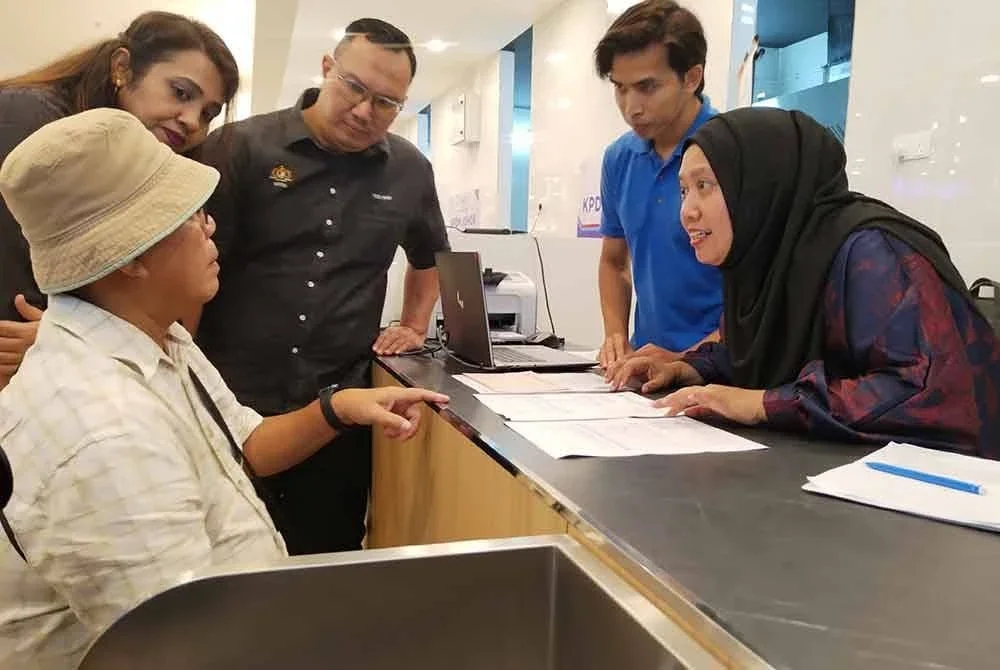 Lilis Saslinda (kanan) beramah mesra dengan pelanggan sempena Program Hari Bertemu Pelanggan KPDN peringkat Negeri Johor bagi Sistem Kawalan Petrol Bersubsidi (SPKS), di sini, pada Selasa.