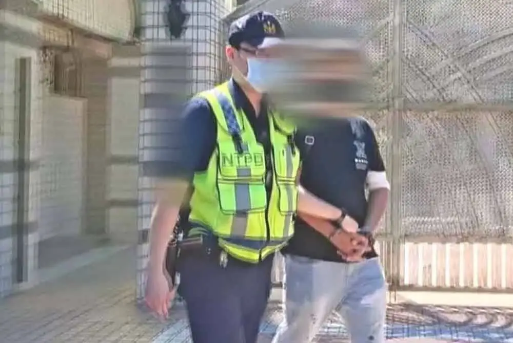 Suspek (kanan) dibawa ke balai polis dari Jalan Jinxiu, Daerah Xindian untuk disiasat. - Agensi