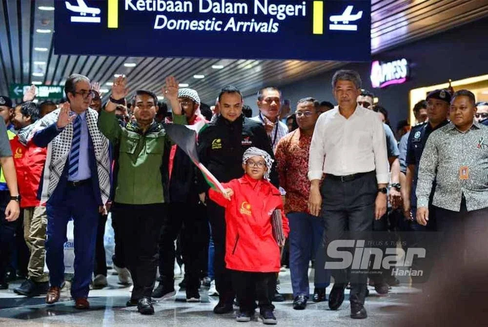 Mohamad (dua dari kanan) menyambut ketibaan sukarelawan GSF di Lapangan Terbang Antarabangsa Kuala Lumpur pada malam Selasa. 