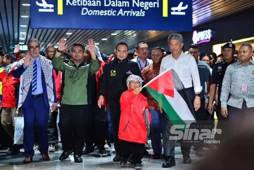Mohamad (dua dari kanan) menyambut ketibaan kumpulan 23 sukarelawan Malaysia di Terminal 1 KLIA pada Selasa. Foto Sinar Harian - ASRIL ASWANDI SHUKOR