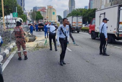 Anggota polis trafik sedang mengawal lalu lintas di lokasi kejadian. FOTO JBPM Kuala Lumpur