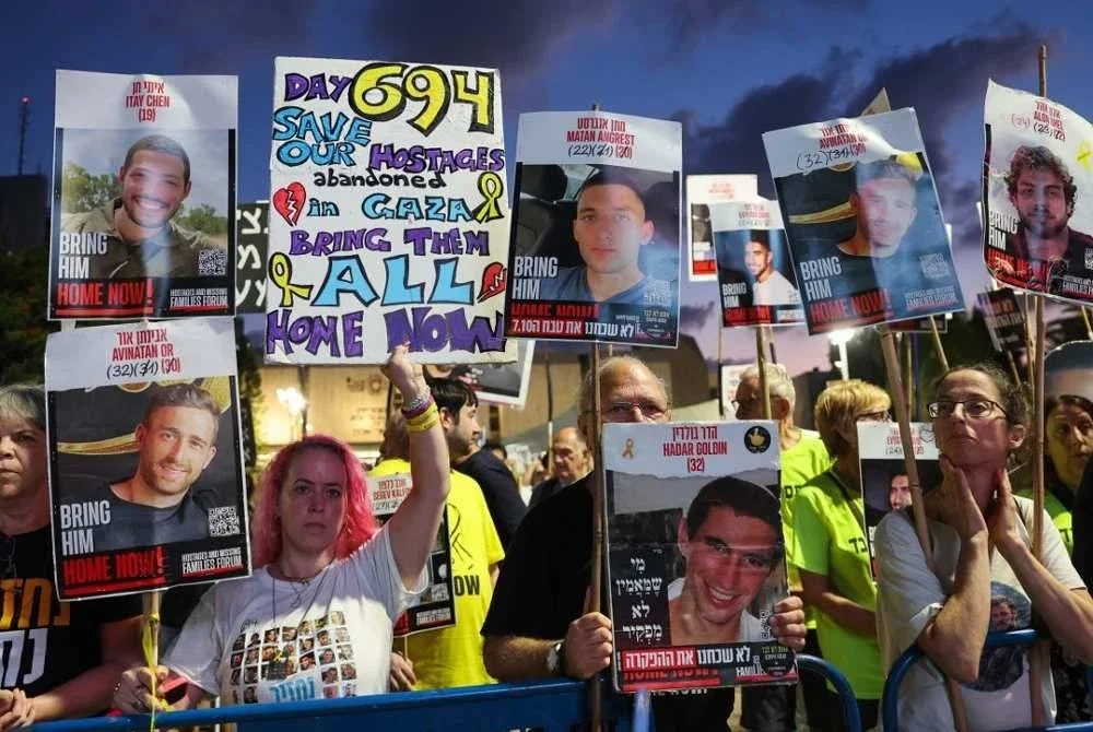 Penunjuk perasaan mengangkat plakad menuntut pembebasan tebusan dan gencatan senjata semasa demonstrasi di Dataran Tebusan, Tel Aviv. Foto AFP