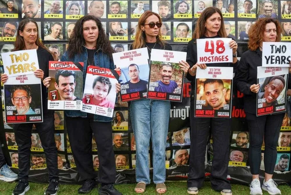 Ahli komuniti Yahudi Australia mengangkat sepanduk dan potret tebusan Israel semasa perhimpunan memperingati ulang tahun kedua serangan Hamas di Sydney. Foto AFP