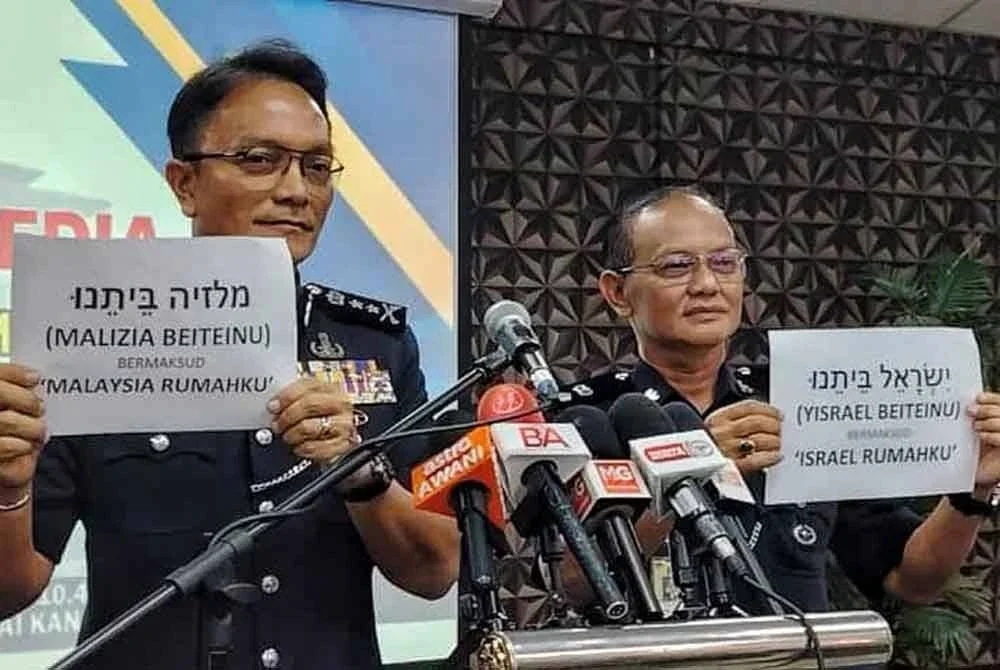 Dzulkhairi (kiri) menunjukkan tulisan Hebrew yang membawa maksud Malaysia Rumahku.