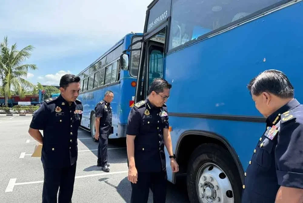 Azrin (tengah) meninjau bas kilang yang disita JPJ menerusi operasi khas di sekitar Negeri Selangor pada Rabu.