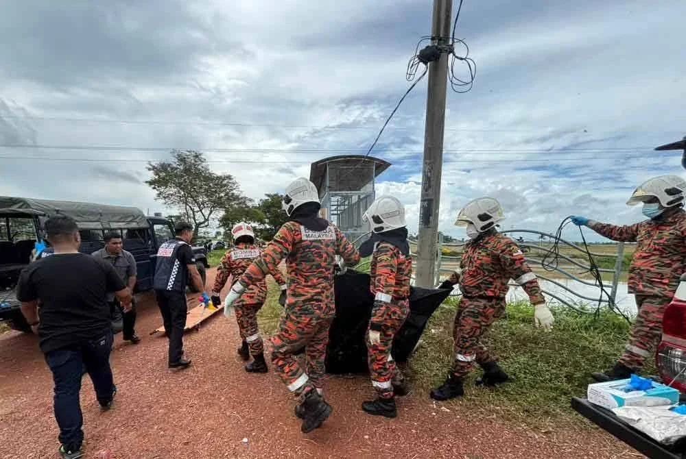 Anggota bomba mengangkat mayat lelaki yang ditemui terapung di dalam tali air di Lahar Ikan Mati pada Khamis.