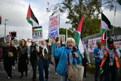 Penunjuk perasaan pro-Palestin mengibarkan bendera di luar fasiliti BAE Systems di Rochester, tenggara England, sambil mendesak kerajaan Britain supaya mengenakan embargo senjata sepenuhnya ke atas Israel. Foto AFP