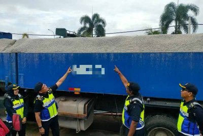 Stien Van Lutam (dua dari kiri) menunjukkan kenderaan perdagangan yang melebihi muatan.