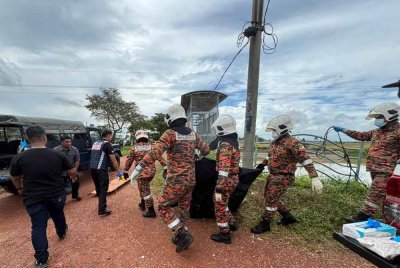Anggota bomba mengangkat mayat lelaki yang ditemui terapung di dalam tali air di Lahar Ikan Mati pada Khamis.