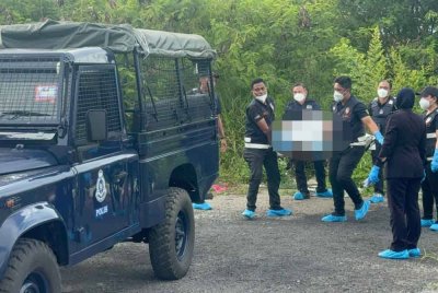 Anggota polis mengangkat mayat mangsa yang ditemui di dalam sebuah beg di Flat Ampang Jajar pada Khamis.