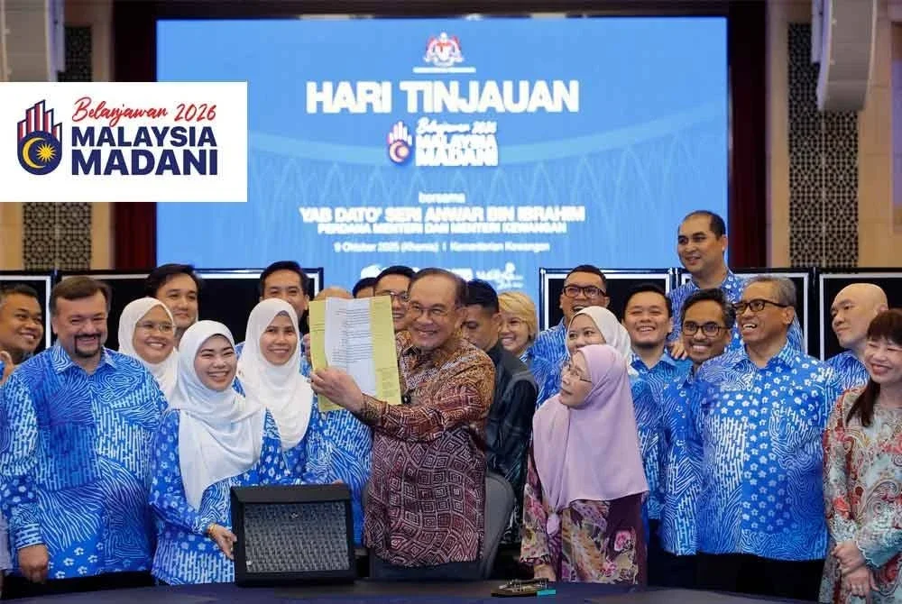 Anwar melihat buku ucapan Belanjawan 2026 semasa hadir ke Hari Tinjauan di Kementerian Kewangan. Foto Bernama