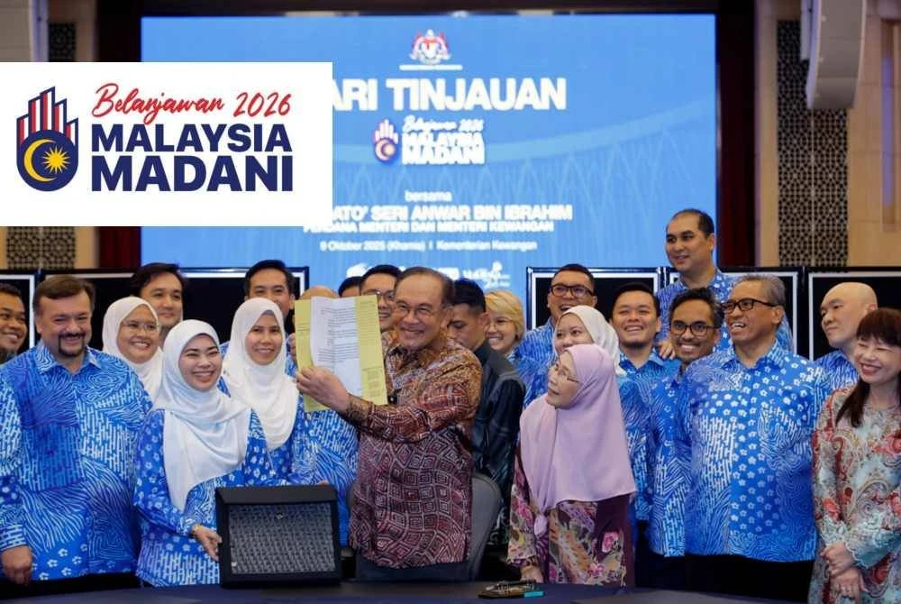 Perdana Menteri merangkap Menteri Kewangan Datuk Seri Anwar Ibrahim melihat buku ucapan Belanjawan 2026 semasa hadir ke Hari Tinjauan di Kementerian Kewangan pada Khamis. Foto Bernama