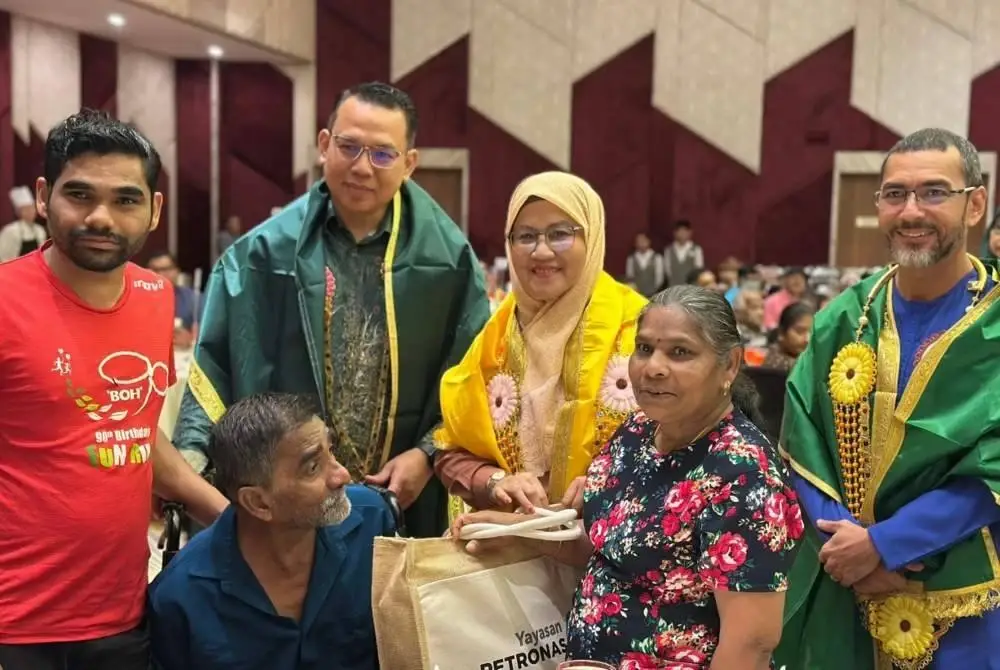 Mohammad Ahmad Shazly (kanan) dan Pengarah Jabatan Kebajikan Masyarakat (JKM) Pahang, Khairul Amri Ahmad (dua dari kiri) mengiringi Sabariah menyampaikan sumbangan Deepavali kepada wakil keluarga sempena Program Memacu Kehidupan: Deepavali di Cameron Highlands pada Khamis.
