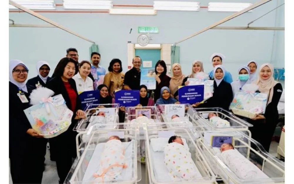 Siew Khim (tengah) bersama Norliza (tujuh dari kanan) bergambar bersama bayi yang baharu dilahirkan di Hospital Seberang Jaya semasa sesi ziarah Program Sumbangan Akaun Simpan SSPN Prime dan Barangan Bayi sempena Program Anak Emas.
