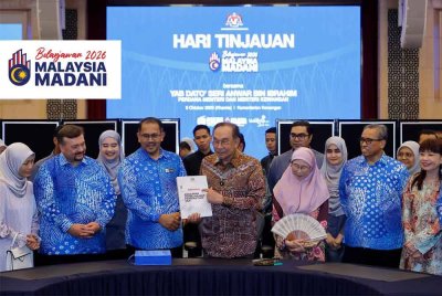 Anwar menunjukan buku Angaran Pebelanjaan Persekutuan semasa hadir ke Hari Tinjauan di Kementerian Kewangan pada Khamis. Foto Bernama