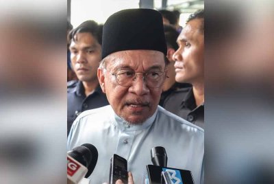 Anwar (tengah) ketika ditemui media selepas menunaikan solat Jumaat di Surau Fathurrahman PPAM Melinjau, Presint 11, Putrajaya. Foto Bernama