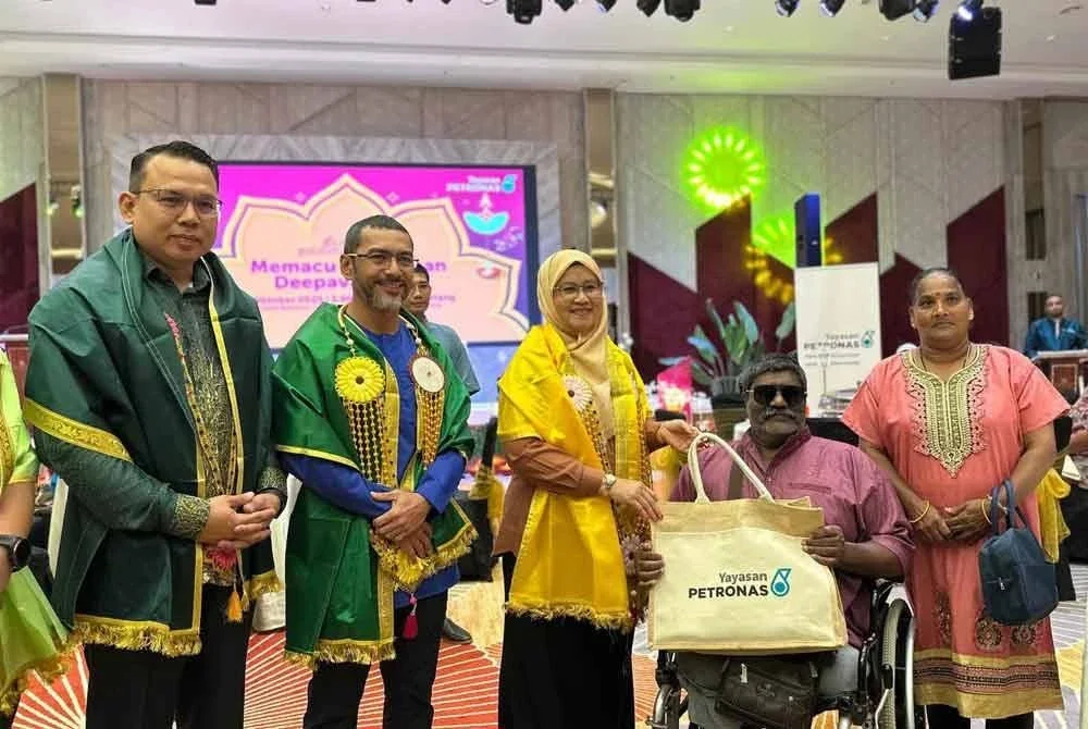 Mohammad Ahmad (dua dari kiri) bersama Khairul Amri (kiri) dan Sabariah (tengah) menyampaikan sumbangan kepada wakil keluarga sempena Program Memacu Kehidupan: Deepavali di Cameron Highlands pada Khamis.