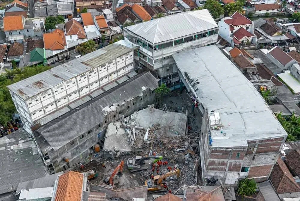 Gambar udara menunjukkan pasukan penyelamat mencari mangsa runtuhan sekolah pondok Al Khoziny di Sidoarjo, Jawa Timur. - AFP