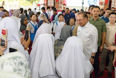 Perdana Menteri, Datuk Seri Anwar Ibrahim beramah mesra bersama para pelajar pada program Majlis Sumbangan Kasih Madani sempena Deepavali 2025 di Sekolah Menengah Jenis Kebangsaan Poi Lam hari ini. Foto Bernama